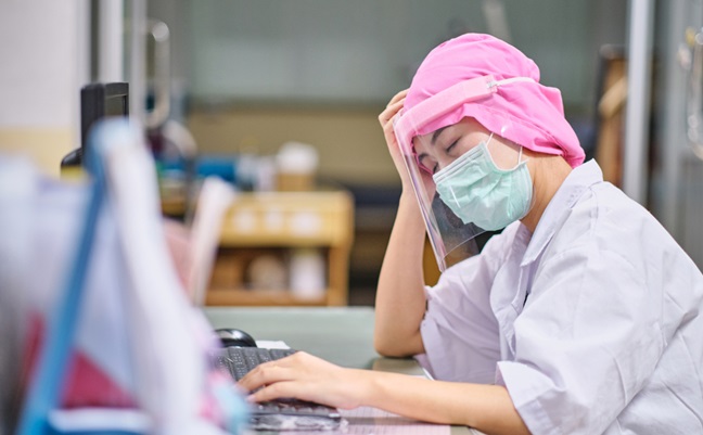 Female,Doctor,Under,Stress,And,Headache,Sleeping,In,Front,Of