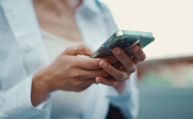 Closeup,Of,Young,Woman,Holds,Smartphone,In,Her,Hands,And