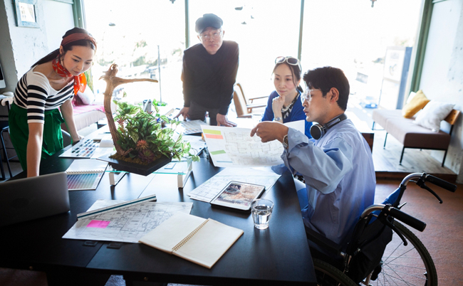 A,Young,Employee,In,A,Wheelchair,Checking,The,Drawings,On