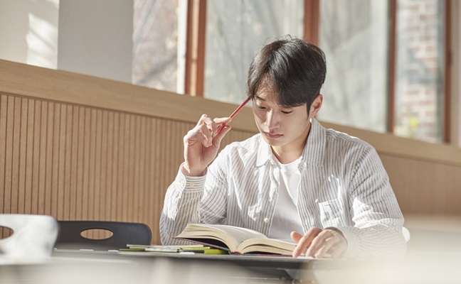 A,Young,College,Student,Is,Sitting,At,A,Desk,In