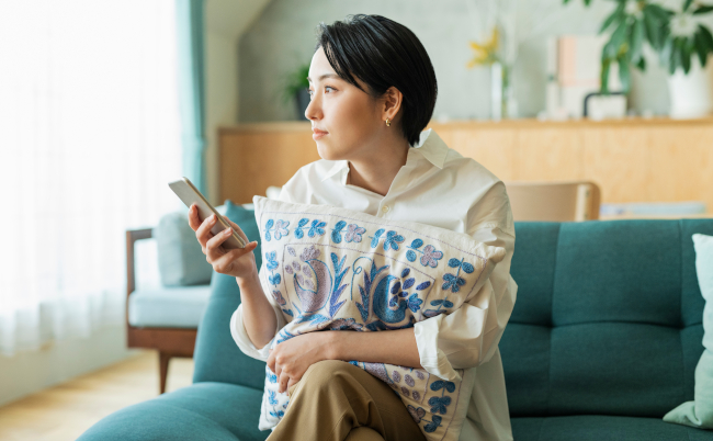 Woman,Looking,At,Smartphone,In,Living,Room