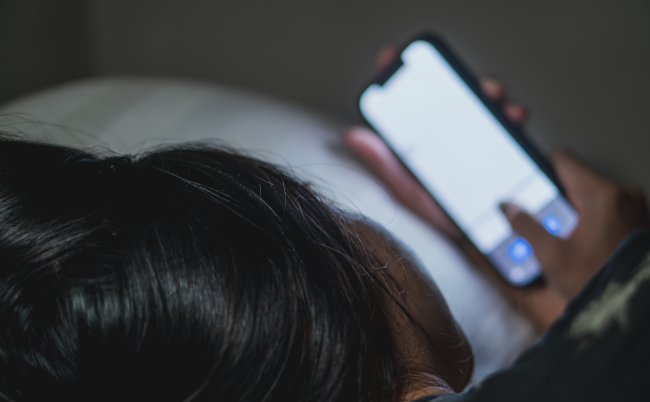 A,Person,Lying,In,Bed,Using,A,Smart,Phone,In