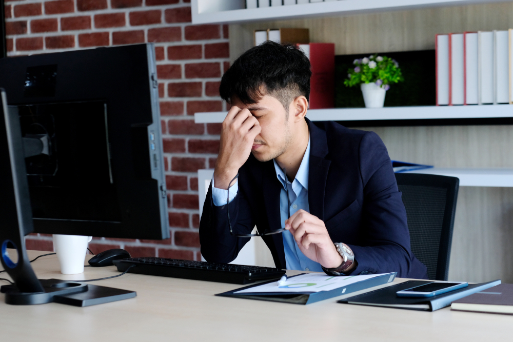 Young,Asian,Businessman,With,Frustrated,Expression,While,Working,With,Computer
