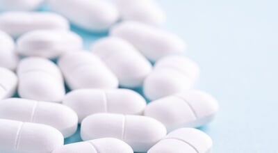 Macro,Photography,Of,White,Medicine,Pills,On,A,Blue,Background.