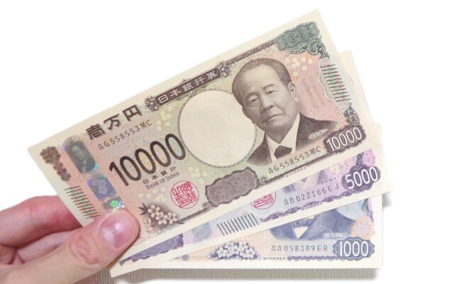 Hand,Holding,New,Japanese,Banknotes,Against,White,Background