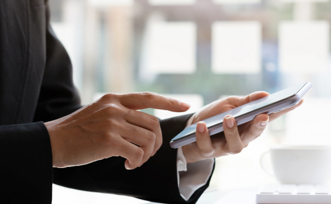 Close,Up,Hand,Of,Woman,Using,Smartphone,At,Office.