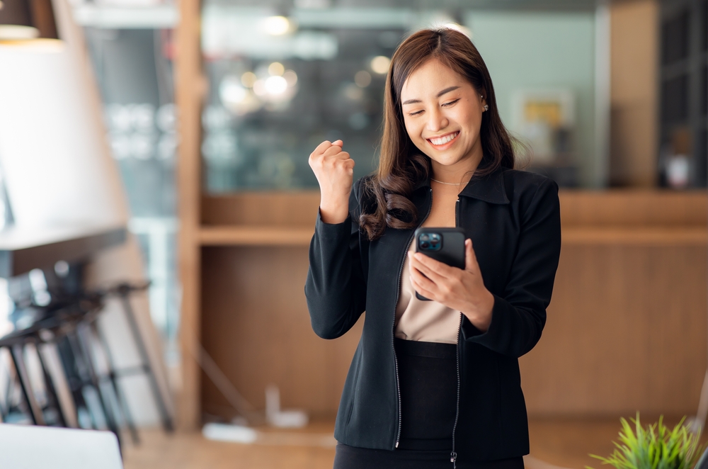 Excited,Happy,Asian,Woman,Looking,At,The,Phone,Screen,,Celebrating