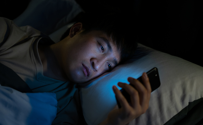 Young,Asian,Man,Using,Smartphone,At,Night
