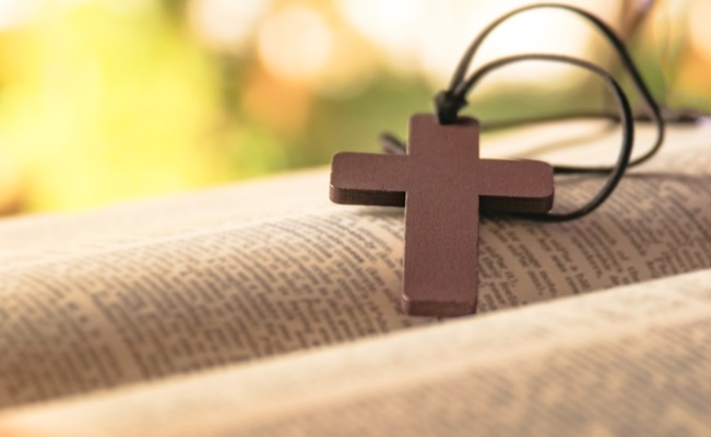 Dark,Brown,Wooden,Cross,On,An,Old,Open,Book,,Symbolizing