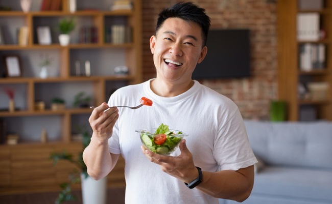 Happy,Asian,Mature,Man,Holding,Fork,And,Bowl,With,Fresh