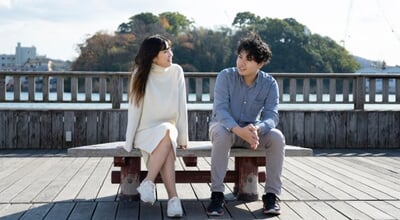 A,Young,Couple,Sitting,On,A,Bench,And,Having,A