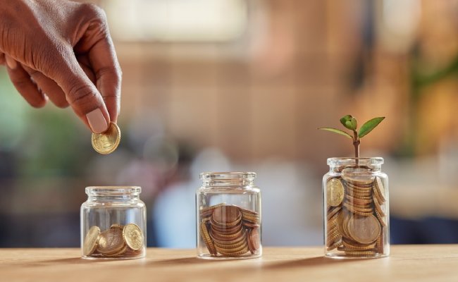 Close,Up,Of,Black,Woman,Hand,Adding,Money,In,Coin