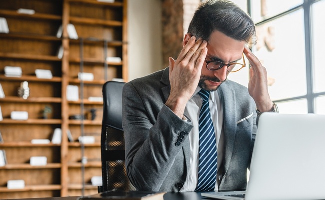 Exhausted,Young,Businessman,Dealing,With,Difficult,Task,Working,On,Laptop