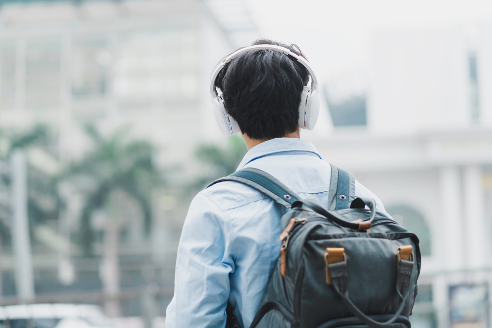The,Man,Is,Wearing,A,Backpack,,Listening,To,Music,And