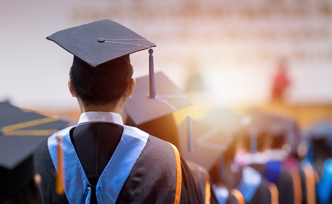 Rear,View,Of,University,Graduates,Wearing,Graduation,Gown,And,Cap
