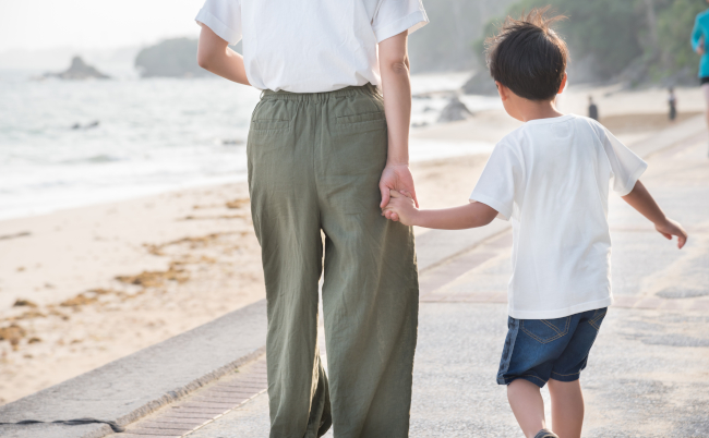 Back,View,Of,Parent,And,Child,Walking,On,The,Beach
