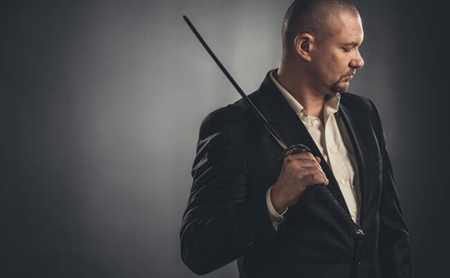 Thoughtful,Man,In,Suit,With,Katana,Sword,On,Black