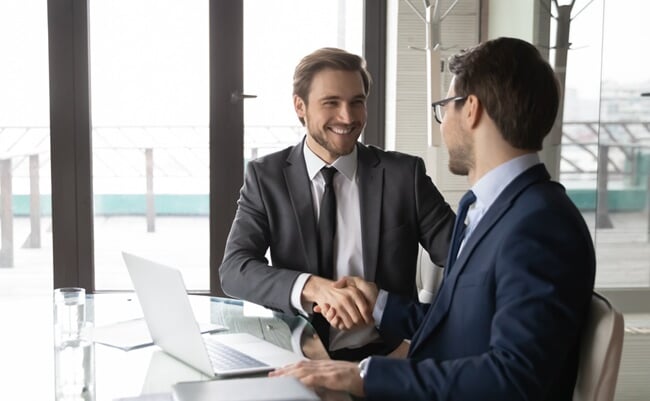 Smiling,Businessman,Shaking,Client,Hand,,Closing,Successful,Deal,,Sitting,At