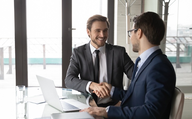 Smiling,Businessman,Shaking,Client,Hand,,Closing,Successful,Deal,,Sitting,At