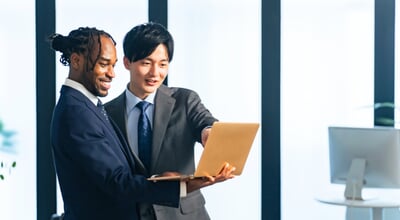 Multinational,Businesspeople,Talking,While,Looking,At,Laptop,Pc,In,The