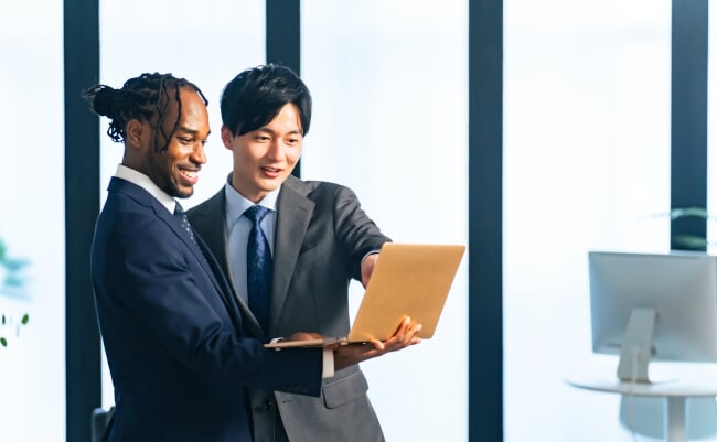 Multinational,Businesspeople,Talking,While,Looking,At,Laptop,Pc,In,The