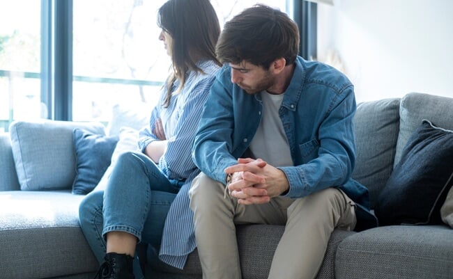 Millennial,Couple,Sitting,On,The,Couch,At,Home,,Facing,Away
