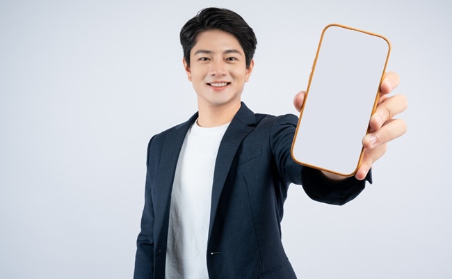 Portrait,Of,Young,Asian,Business,Man,Using,Phone,And,Posing