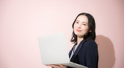 A,Young,,Cute,Woman,In,A,Suit,Holding,A,Computer,