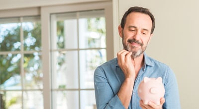 Middle,Age,Man,Save,Money,On,Piggy,Bank,Serious,Face