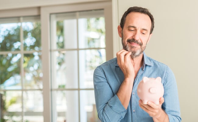 Middle,Age,Man,Save,Money,On,Piggy,Bank,Serious,Face