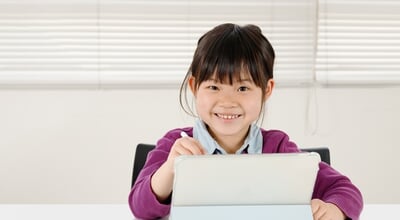 A,Smiling,Elementary,School,Girl,Operating,A,Tablet,Device.