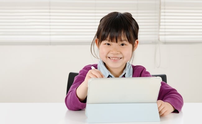 A,Smiling,Elementary,School,Girl,Operating,A,Tablet,Device.