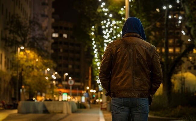 Rear,View,Of,Adult,Man,On,Street,At,Night,With