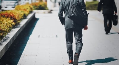 Back,View,Of,A,Businessman,Walking,In,An,Office,District