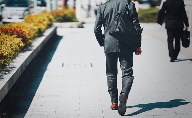 Back,View,Of,A,Businessman,Walking,In,An,Office,District