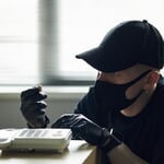 Man,Wearing,Black,Cap,And,Mask,Tampering,With,Landline,Phone