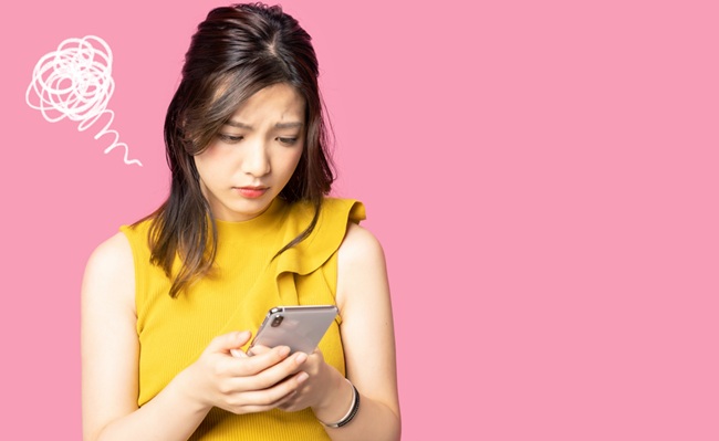 Depressed,Young,Asian,Woman,Watching,A,Smart,Phone.