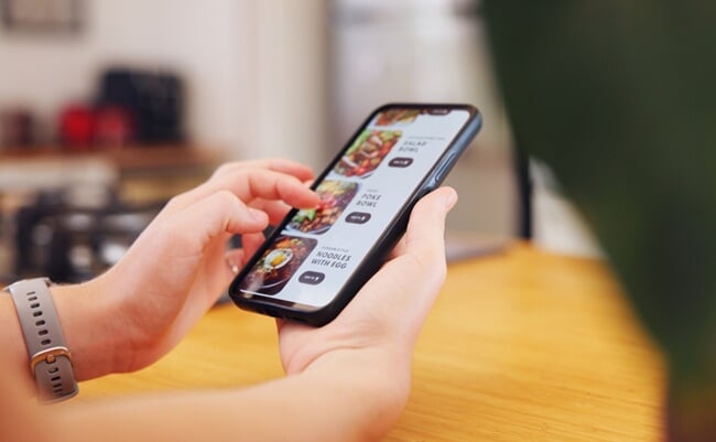 Hands,,Person,And,Phone,Screen,Of,Online,Shopping,With,Food