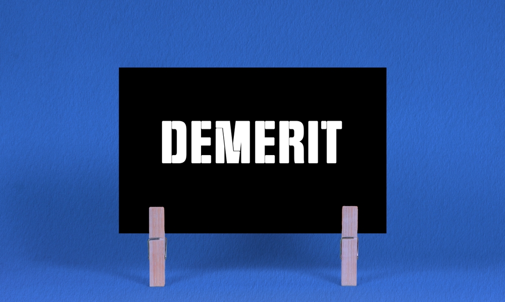 Demerit,Symbol.,Concept,Words,Demerit,On,Black,Rectangle,Paper,Held