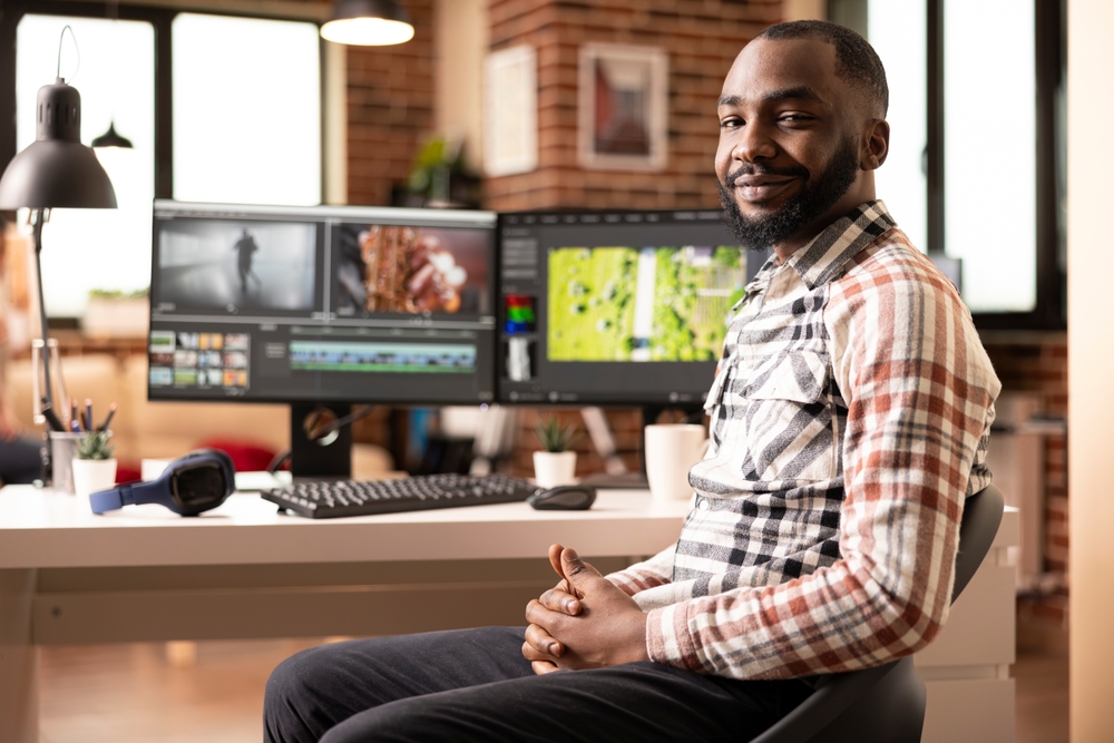 Portrait,Of,Confident,Male,Videographer,Seated,At,Creative,Home,Studio.