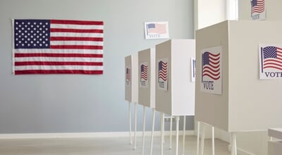 White,Empty,Voting,Booths,At,Polling,Station,With,American,Flag.