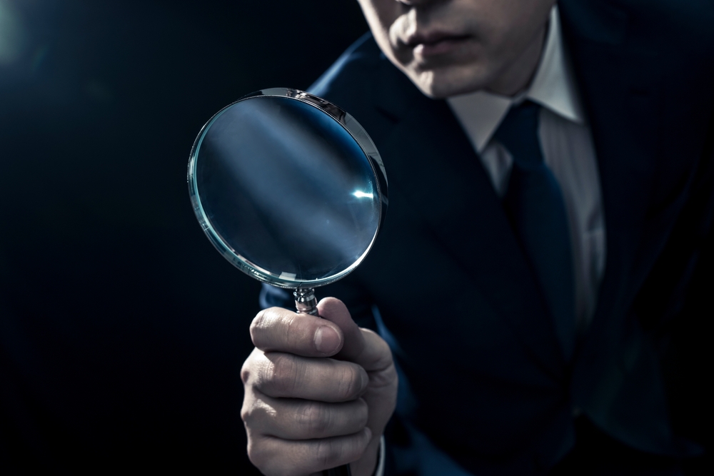 Male,Businessman,Peering,Through,Magnifying,Glass