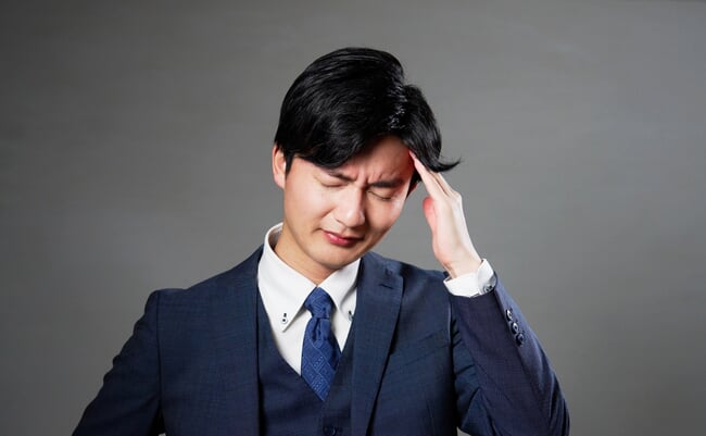 Asian,20s,Businessman,Having,A,Headache,In,Black,Background