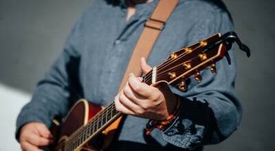 Close-up,Of,A,Musician,Strumming,An,Acoustic,Guitar,,Showcasing,Detailed