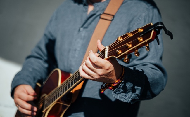 Close-up,Of,A,Musician,Strumming,An,Acoustic,Guitar,,Showcasing,Detailed