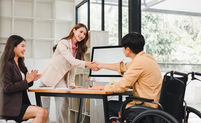 Businesswoman,Shaking,Hands,With,Man,In,Wheelchair,,Diverse,Team,Celebrating