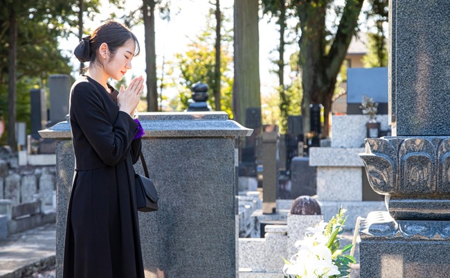 A,Bereaved,Woman,Visiting,The,Grave,At,The,Burial,Ceremony