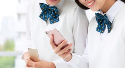Female,Student,In,Uniform,With,Smartphone