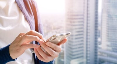 A,Woman,Operating,A,Smartphone,With,The,City,In,The