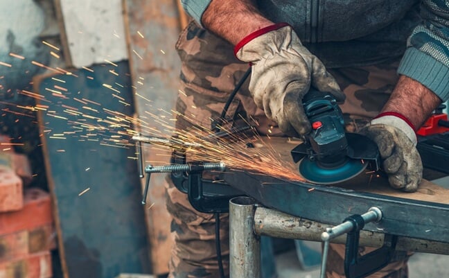 Close-up,Of,Manual,Worker,Operating,Grinder,With,Intense,Sparks,,Highlighting